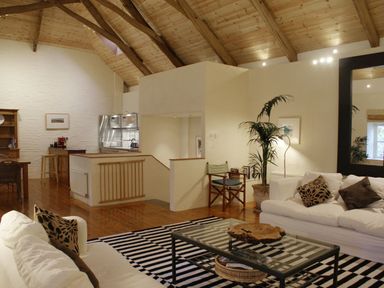 A living room with white sofas and a striped rug at The Barn in Aveton Gifford