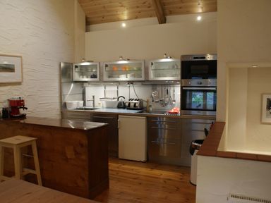 A kitchen with stainless steel cabinets appliances and wooden floor at The Barn in Aveton Gifford