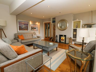 A living room with sofas a coffee table and a fireplace at Dove Cottage in Dittisham
