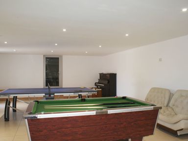 A game room with a pool table, a ping pong table, a piano, and two armchairs at Oak Tree in Halwell
