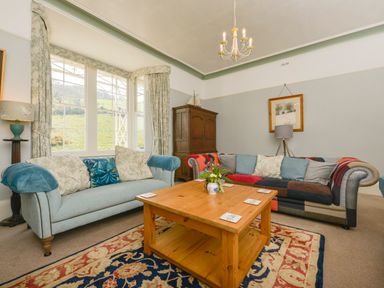 A living room with two sofas a wooden coffee table and a large window at Woodlands in Dartmouth
