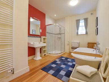 A bathroom with a freestanding bathtub a pedestal sink a corner shower and a toilet at Woodlands in Dartmouth