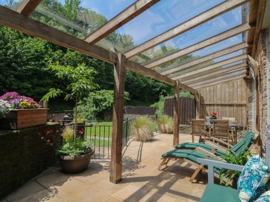 An outdoor patio with a table and chairs at Fixit Cottage in Kingsbridge