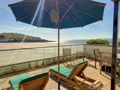 An outdoor terrace with sun loungers and a view of the sea at 5 Burgh Island Causeway Bigbury-on-Sea