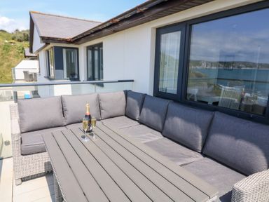 An outdoor seating area with a sofa and table at 27 Burgh Island Causeway in Bigbury-on-Sea