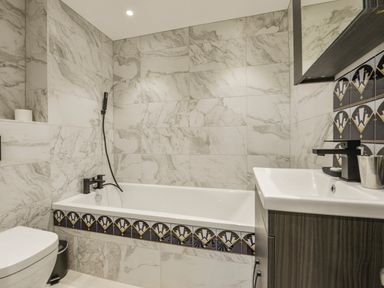 A bathroom with a bathtub shower toilet and sink at 24 Burgh Island Causeway in Bigbury-on-Sea