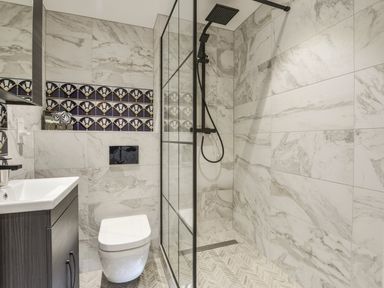 A bathroom with a shower area enclosed by glass and a wall-mounted toilet at 24 Burgh Island Causeway in Bigbury-on-Sea