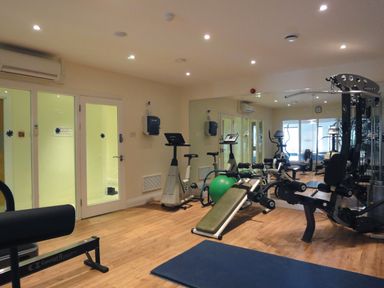 A gym room with exercise bikes weight bench exercise ball and multi gym machine at 23 Burgh Island Causeway in Bigbury-on-Sea