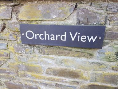 A sign with the text Orchard View mounted on a stone wall at Orchard View in Kellaton near Hallsands