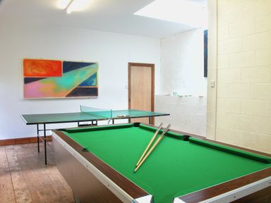 A game room with a pool table and a ping pong table and modern art on the wall at Mixit Cottage in Kingsbridge