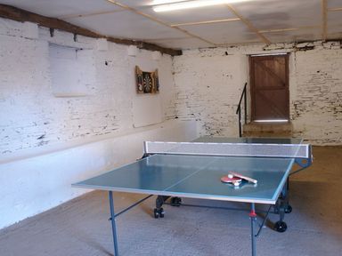 A game room with a ping pong table and dartboard on a white brick wall at Maristow Barton Milton Combe near Lopwell Dam