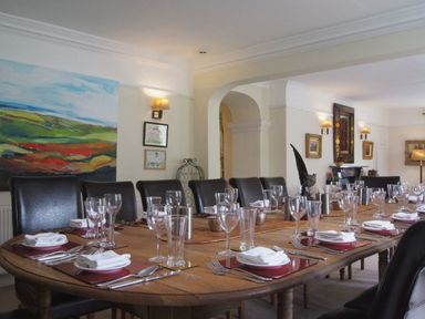 A dining room with a wooden table set with plates glasses and cutlery at Maristow Barton in Milton Combe near Lopwell Dam