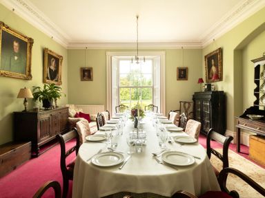 A dining room with a long table set for dinner at Parnacott in Holsworthy