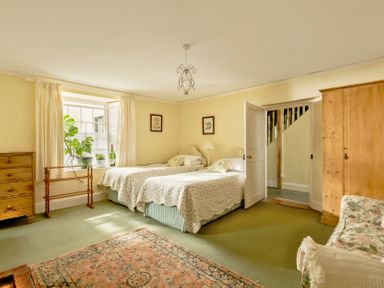 A bedroom with two beds and a wardrobe at Parnacott in Holsworthy
