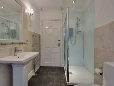 A bathroom with a sink and mirror towel rack shower enclosure and toilet at Higher Tumrose in Blisland