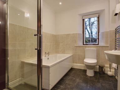 A bathroom with a bathtub shower toilet sink and window at Higher Tumrose in Blisland
