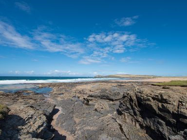 A coastal scene with rocks and ocean at Grandpa Dickson's in Little Petherick