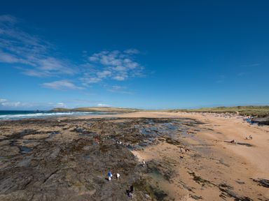 A beach with rocks and people at Grandpa Dickson's in Little Petherick