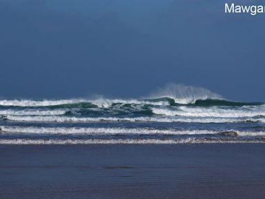 Waves breaking on the shore with a clear sky at Seagulls Perch in Mawgan Porth