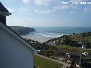 A coastal view with houses cliffs and sea at Seagulls Perch in Mawgan Porth