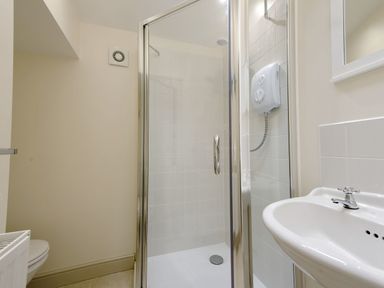 A bathroom with a glass shower enclosure a white sink and a toilet at Nirvana Kingsand And Cawsand
