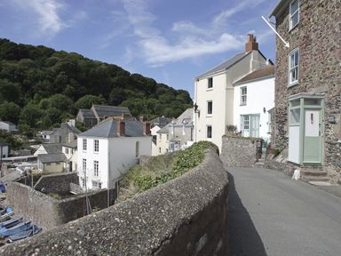 A narrow street with stone walls and houses surrounded by trees at Balcony Cottage in Kingsand And Cawsand