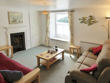 A living room with two sofas a coffee table and a window view at Balcony Cottage in Kingsand And Cawsand