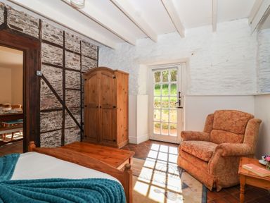A bedroom with a bed and wardrobe at Tregonhawke Farmhouse in Millbrook