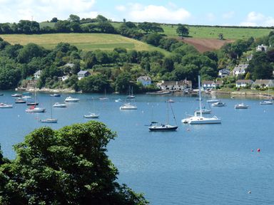 A body of water with boats and houses near green hills at Regatta Cottage in Feock