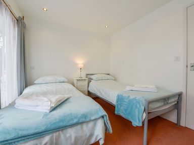 A bedroom with two single beds and a bedside table with a lamp at Hideaway Barn in Charlestown