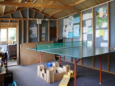 A room with a table tennis table wooden toy castle and drawings pinned to walls at Swift Cottage in Mawgan-in-Meneage near Helston