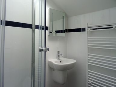 A bathroom with a sink mirror shower and towel rack at The Studio in Rinsey Cove near Praa Sands