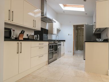 A kitchen with beige cabinets black countertops stainless steel appliances and a skylight at 33 Crescent Gardens in Bath