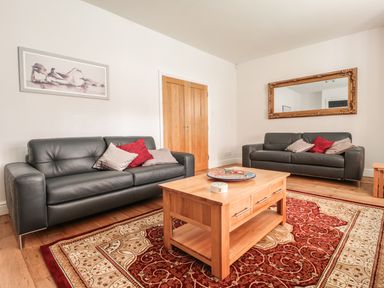 A living room with two leather sofas a wooden coffee table and a large rug at 33 Crescent Gardens in Bath