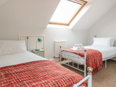 A bedroom with two single beds red throws and a skylight window at 33 Crescent Gardens Bath