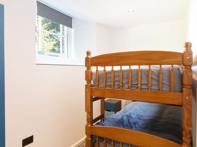 A bedroom with wooden bunk beds next to a window at Moor View Chapel in Camelford