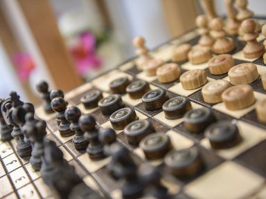A wooden chess and checkers board with pieces set up at Little Retreat in Liskeard