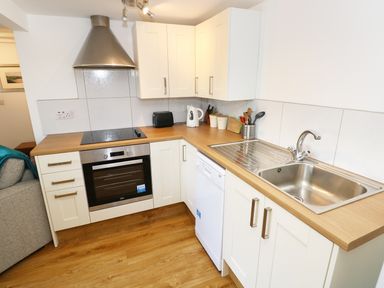 A kitchen with oven stove hood cabinets sink and dishwasher at The Granary Cottage in Llangrannog near Cardigan