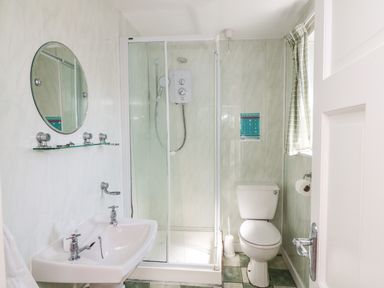 A bathroom with a shower cabin sink mirror toilet and a window at Grange Farmhouse in Fethard-on-Sea County Wexford