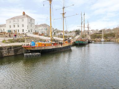 Sailboats docked in a harbor near a building labeled Pier House at Oh Buoy Charlestown