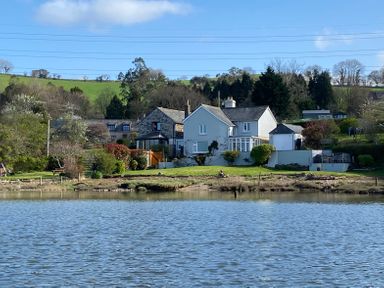 A house with a garden and trees beside a body of water at Clamoak Cottage Clamoak near Bere Alston
