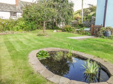 A garden with a small pond surrounded by stones and grass at Dale House in Lorton