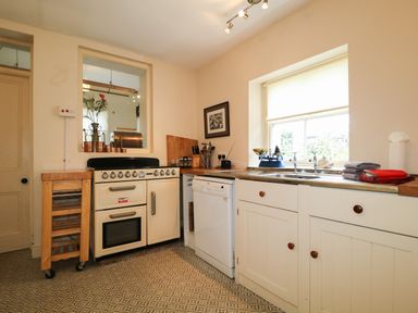 A kitchen with a stove dishwasher sink and window at Dale House in Lorton