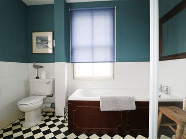 A bathroom with a toilet bathtub with a towel window and stool at Dale House in Lorton