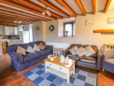 A living room with sofa and coffee table at Old Farmhouse Cottage