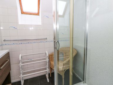 A bathroom with shower and towel rack at Old Farmhouse Cottage