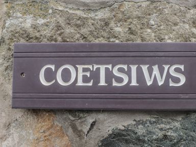 A sign reading Coetsiws mounted on a stone wall at Coetsiws in Clynnog Fawr