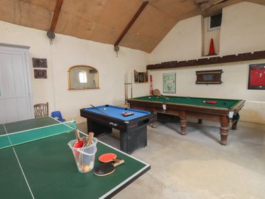 A game room with a pool table and table tennis table at Coetsiws in Clynnog Fawr