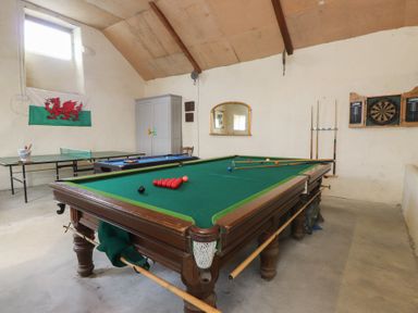 A recreational room with a pool table and darts board at Coetsiws in Clynnog Fawr