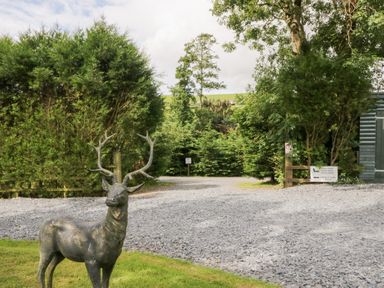 An outdoor area with a deer statue and gravel path at Oak Lodge Pennington near Ulverston